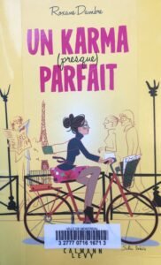 Couverture de Un karma (presque) parfait de Roxane Dambre : un dessin d'une jeune femme qui traverse Paris en vélo, avec une pochette de documents.