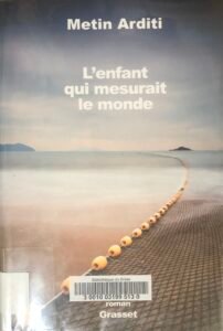 Couverture de L'enfant qui mesurait le monde de Metin Arditi : un filet de pêche court sur une mer tranquille, vers l'horizon, avec deux îles, avec une harmonie de couleurs entre le ciel et la mer.