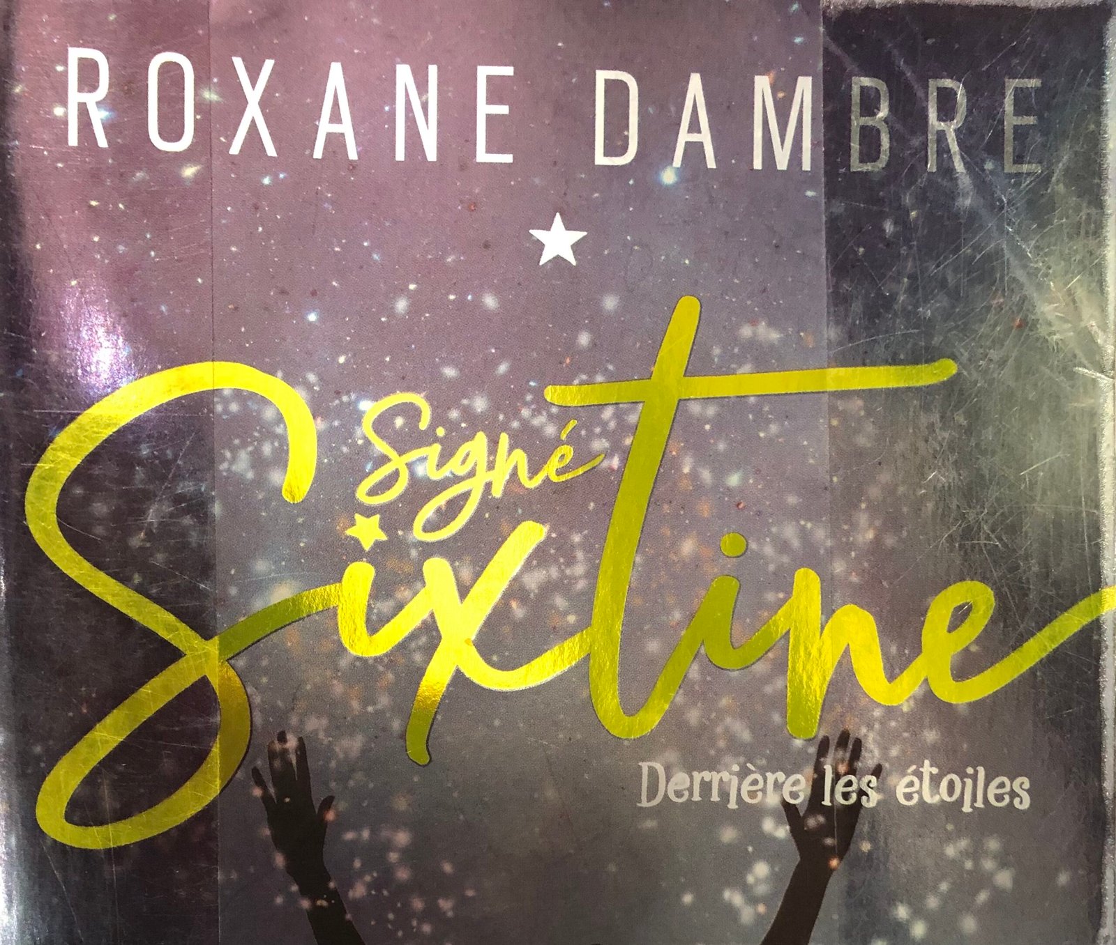 Extrait de la Couverture de Signé Sixtine 1, de Roxane Dambre. Silhouette d'une jeune femme qui tend les bras vers le ciel sur fond étoilé.