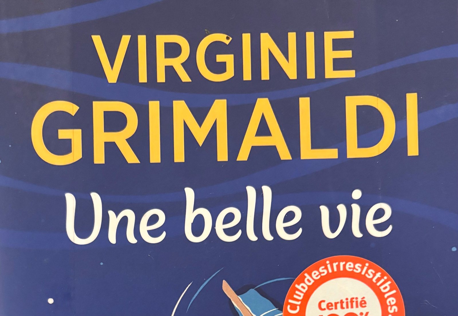 Extrait de la Couverture de Une belle vie de Virginie Grimaldi : deux jeunes femmes allongées sur une planche de surf, sur l'océan.