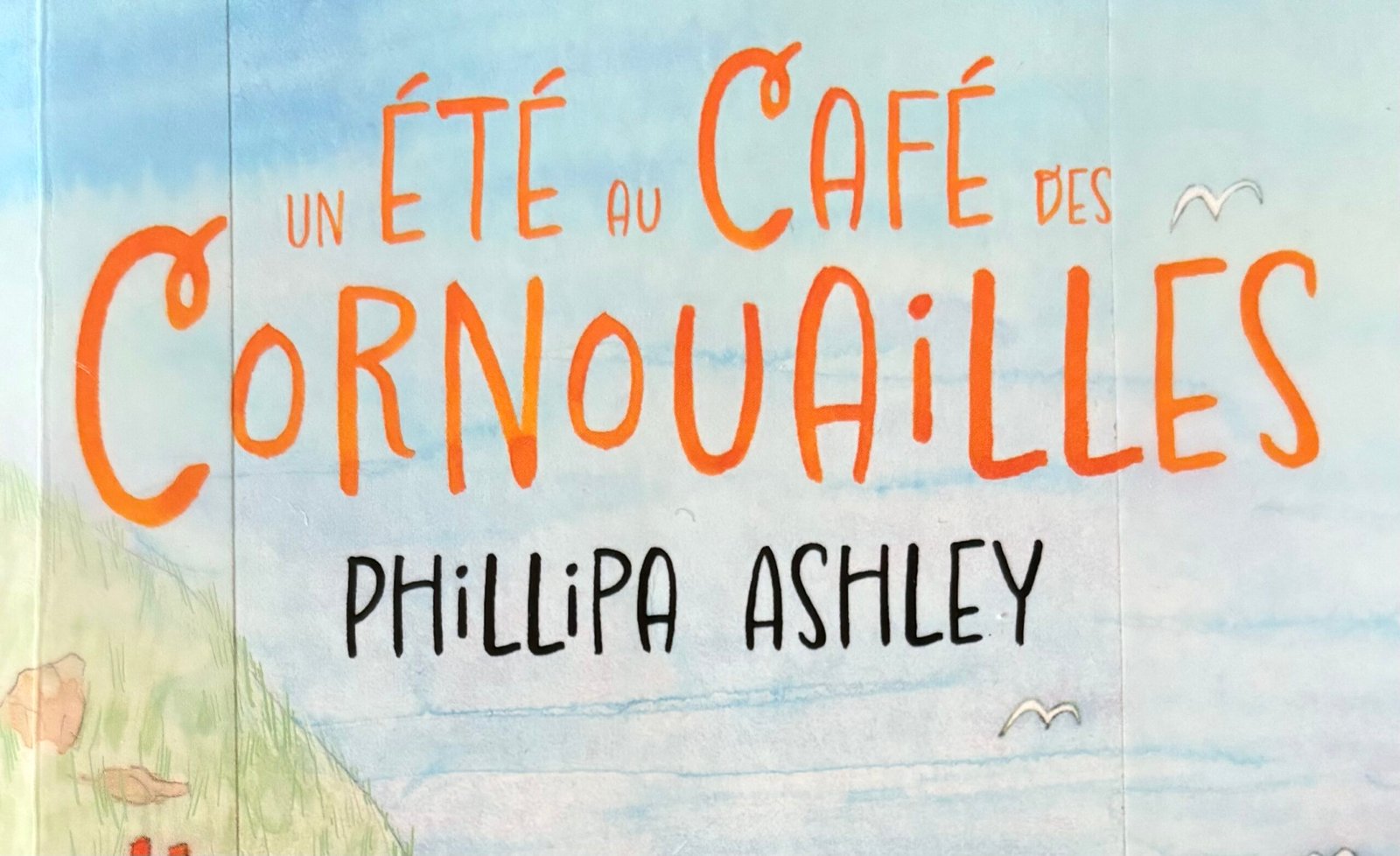 extrait de la Couverture de Un été aux Cornouailles de Phillipa Ashley : un café dans une vieille maisonnette en pierres au bord de la mer.