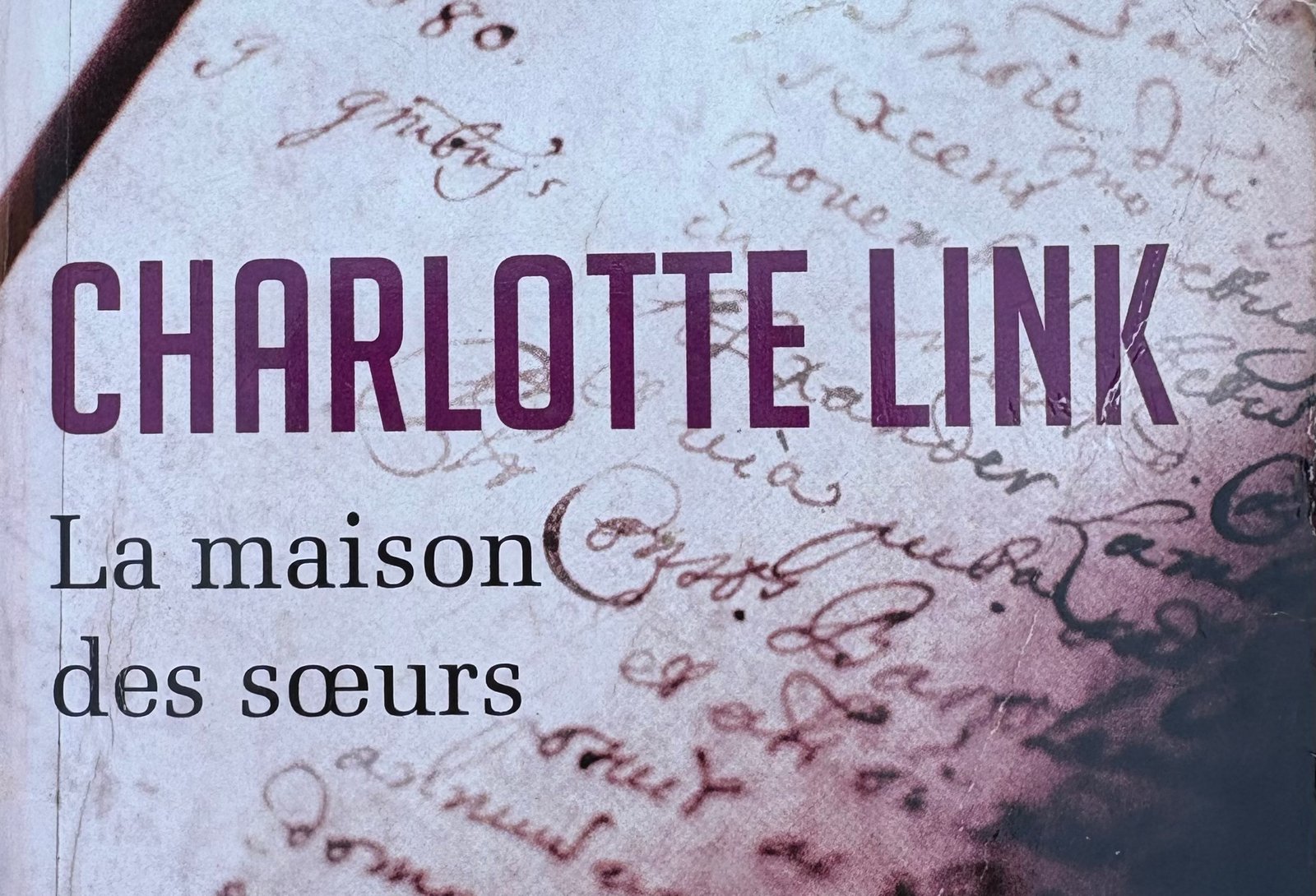 Extrait de la Couverture de La maison des soeurs par Charlotte Link, avec les pages d'un manuscrit en fond