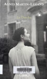 Couverture de La Datcha, d'Agnès Martin-Lugand : une photo en noir et blanc montre une jeune femme de dos regardant la façade d'une bâtisse