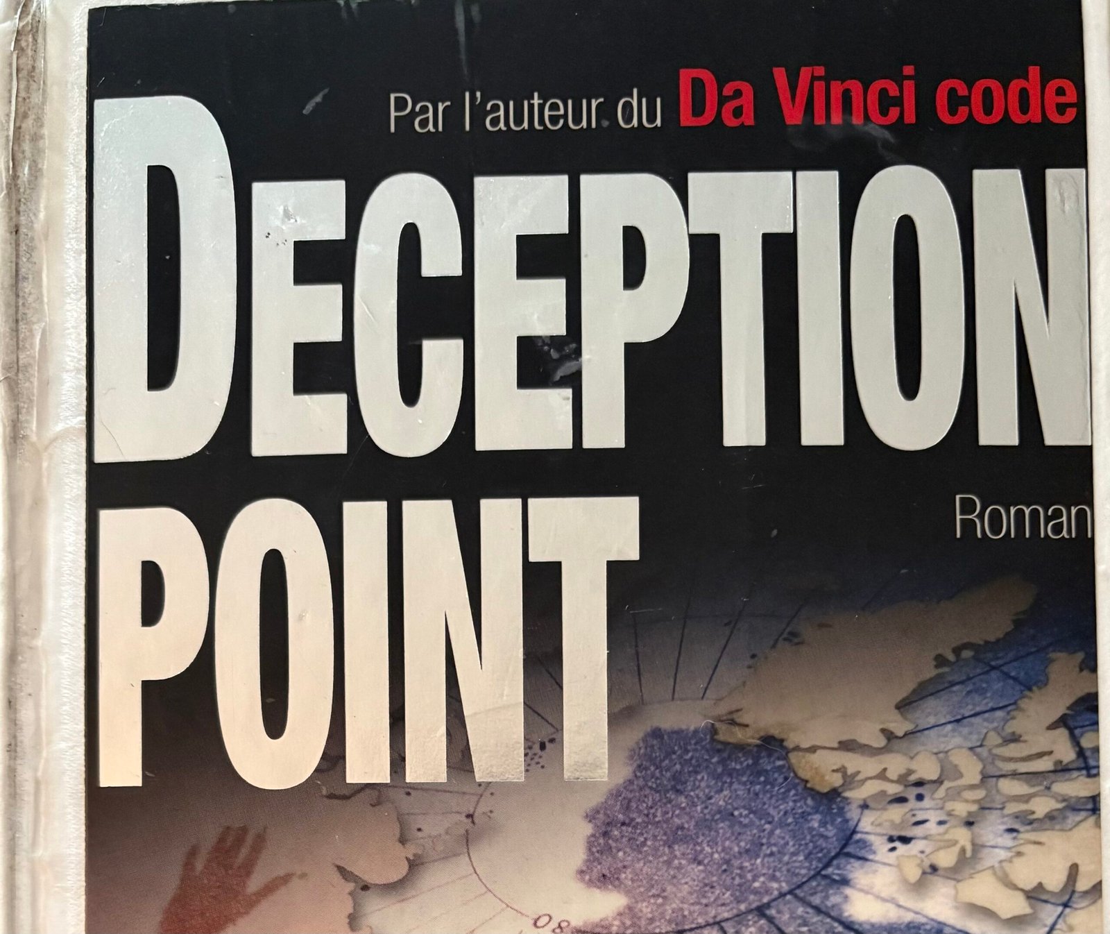 Extrait de la Couverture de Deception Point de Dan Brown : l'ombre d'un homme sur une mappemonde, côté Pôle Nord